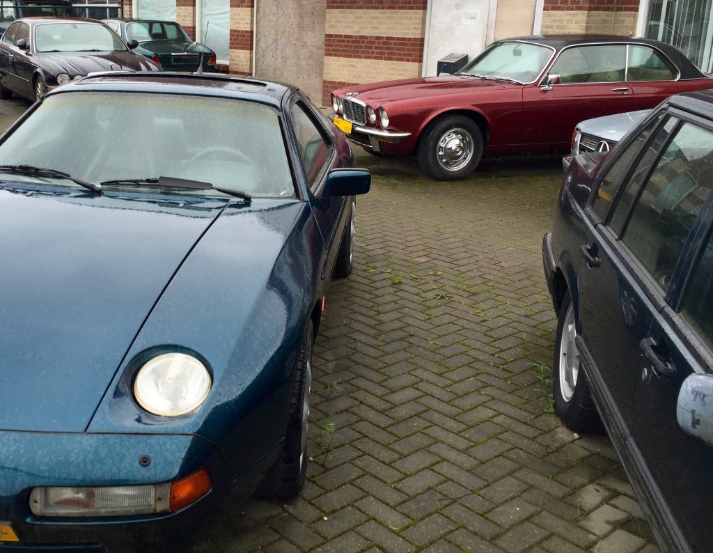 Gran Tourismo der 70er Jahre: Ein dunkelrotes XJ-C 4.2 V6 Coupé von 1978, eingerahmt von einem Porsche 928 und einem Mercedes-Benz C126 S-Klasse Coupé